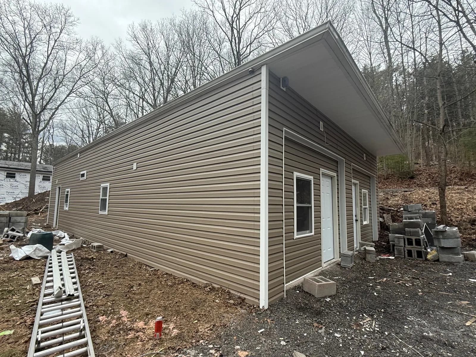 Complete vinyl siding replacement with brown siding and white trim on Stroudsburg PA home — front corner view showing full exterior transformation